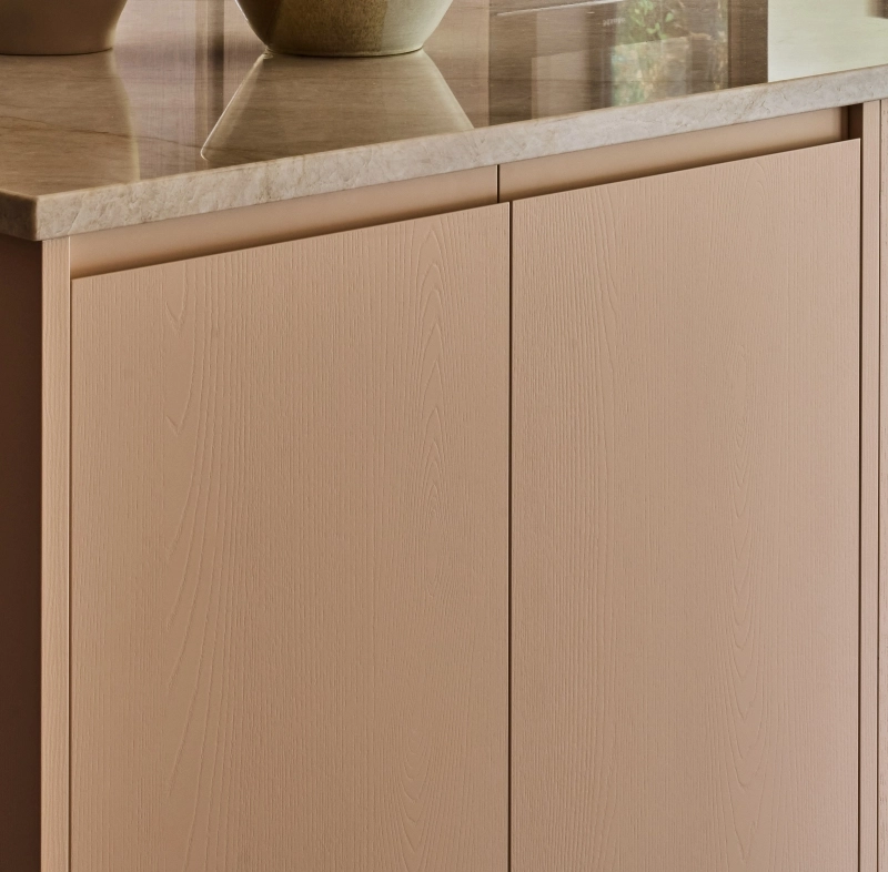 Light blue kitchen cabinet with a wood grain pattern. It has a simple design with a round, dark metal knob. Golden hinges attach the cabinet door to the frame.