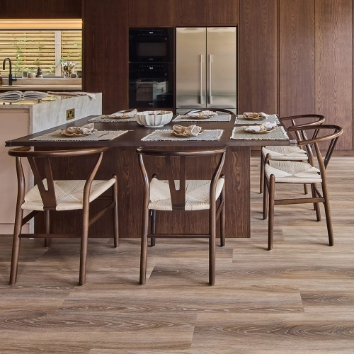 Close-up of a cabinet with three purple wooden drawers, each featuring a silver handle. The top is made of white marble with gray veining. The cabinet stands on a light-colored wooden floor.