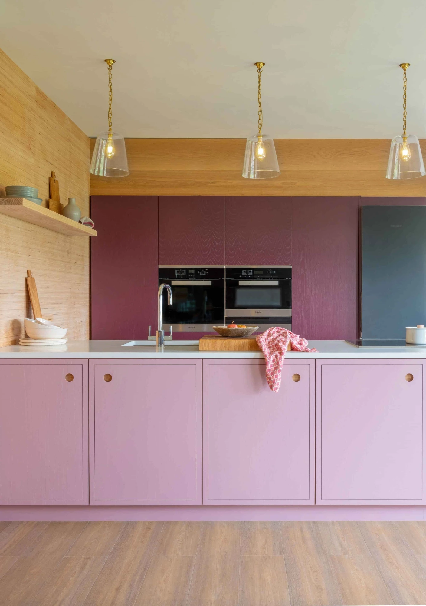 Integrated Miele appliances seamlessly blend into the pink & purple design, ensuring both style & functionality in this contemporary kitchen.