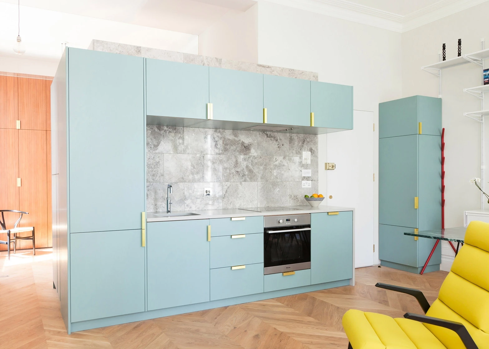 Blue doors with sleek handles with golden accents showcase the bespoke craftsmanship.