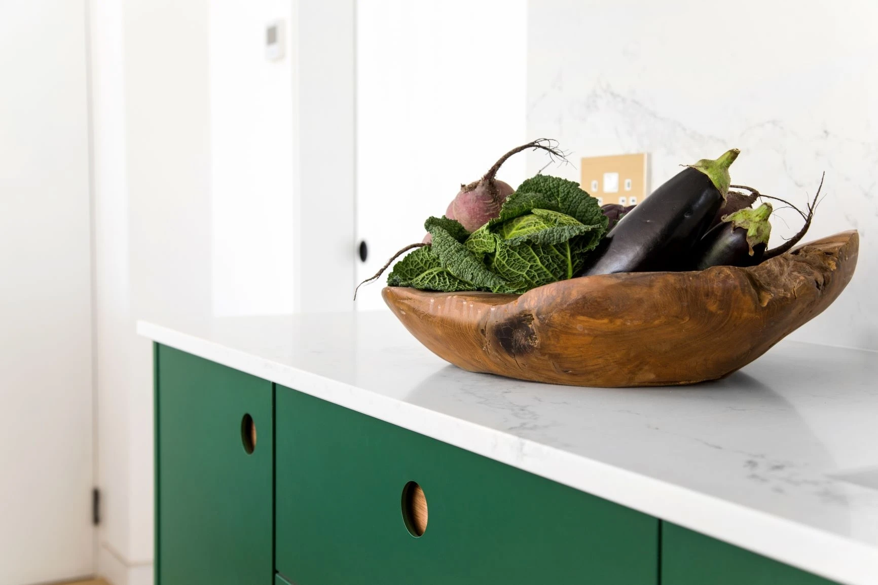 Neutrally painted walls provide a canvas for the bold yet elegant Wiveton Fern green Ladbroke doors, showcasing the bespoke design.