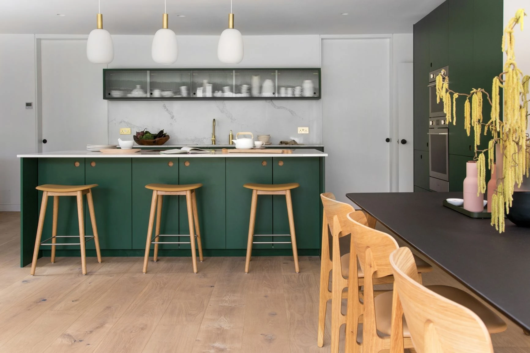 Oak Ladbroke handle backing echoes throughout the room, seen in the bar stools and chairs, further connecting the kitchen to the outdoors.