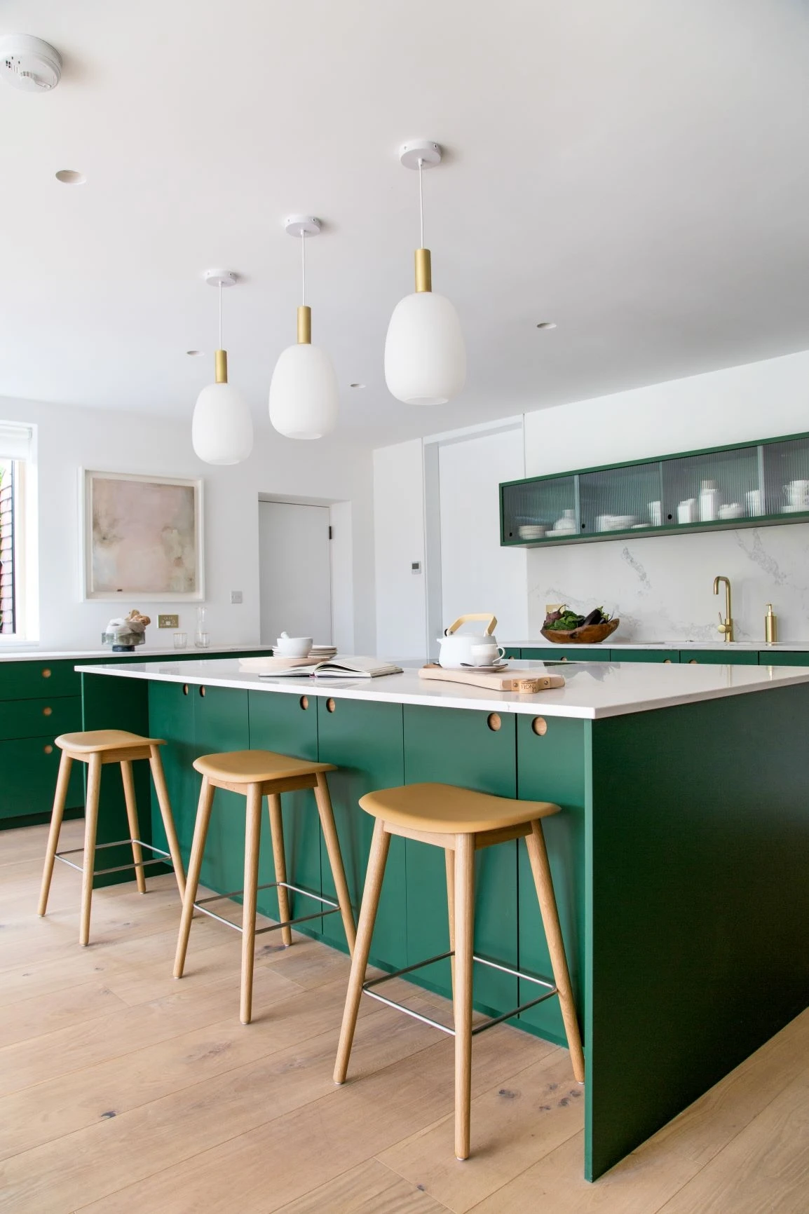 The kitchen island provides a welcoming spot for casual dining or entertaining guests, with stools neatly tucked away when not in use.