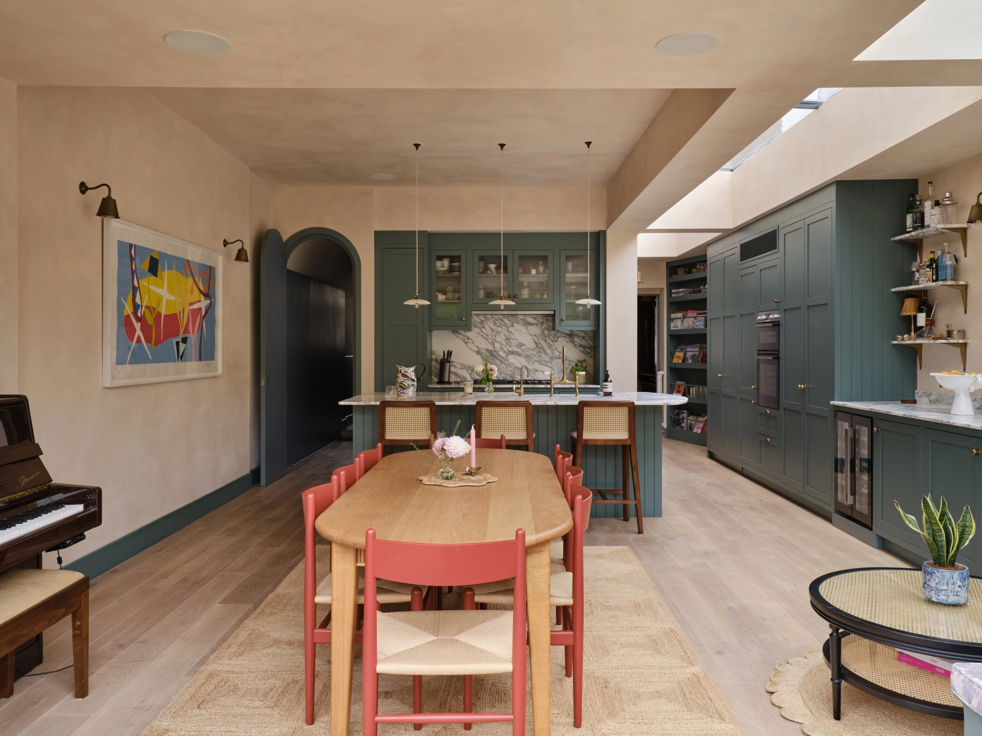 Close-up of a wooden cabinet with two open doors featuring round, textured metal knobs. Inside, there are neatly stacked plates with gold rims. The cabinet is set on a marbled surface