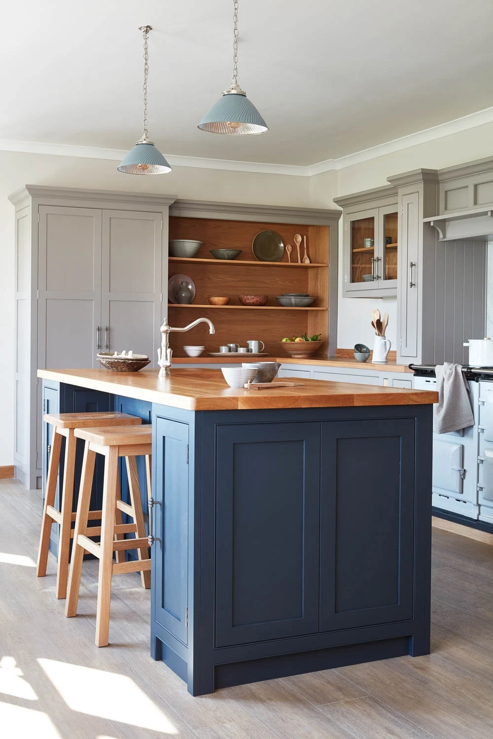 Traditional Shaker cabinets with corbels and beading blend seamlessly with a statement Aga, creating a timeless farmhouse kitchen.