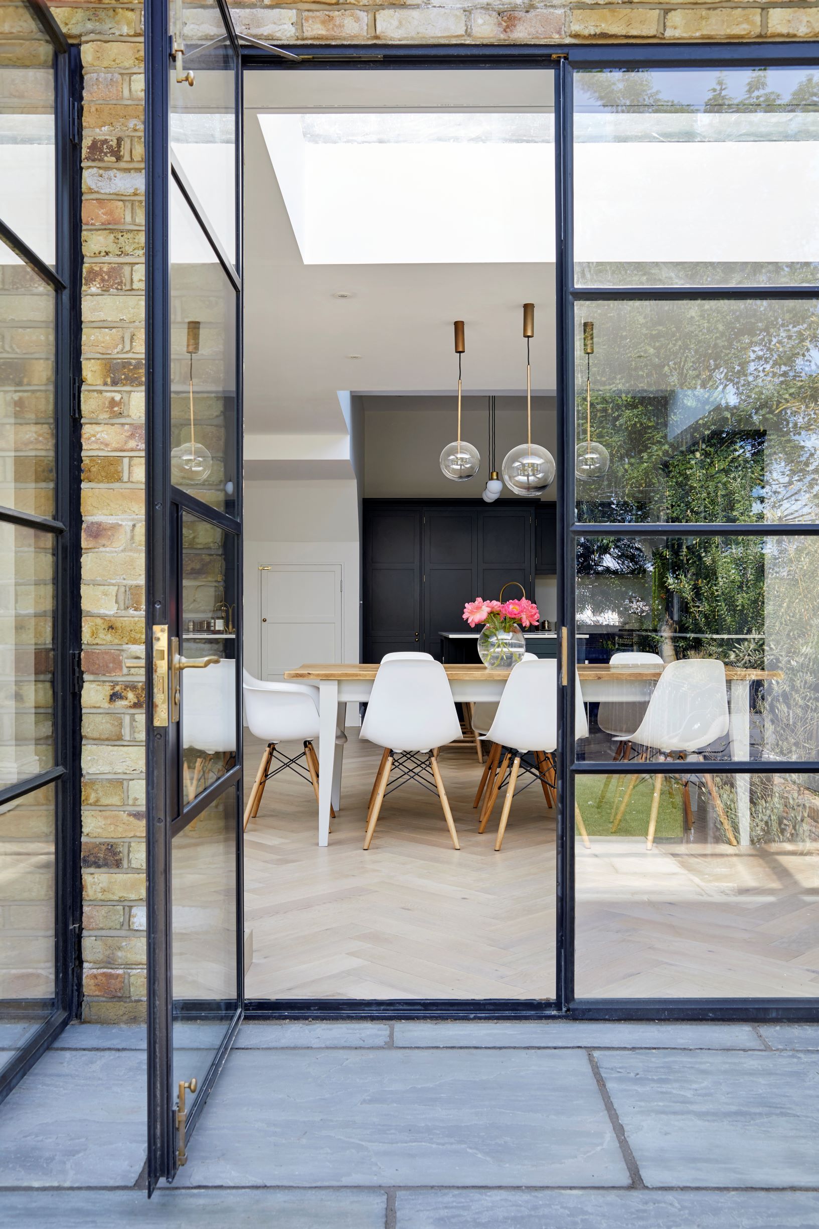 Embrace minimalism with Heathwood Gardens, featuring dark blue cabinetry, white marble worktops, and beautiful glazed units. Ample seating, storage and a skylight make it a perfect family kitchen.