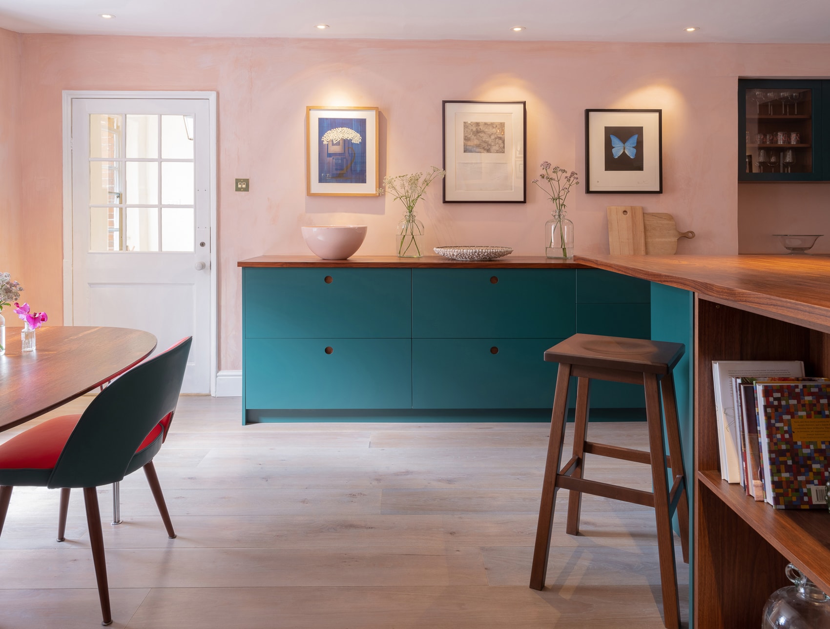 A chic and contemporary masterpiece, the circular handle detail and bold red Aga are the showstoppers. Walnut and the rich green-blue work harmoniously while brass accents add a touch of elegance.