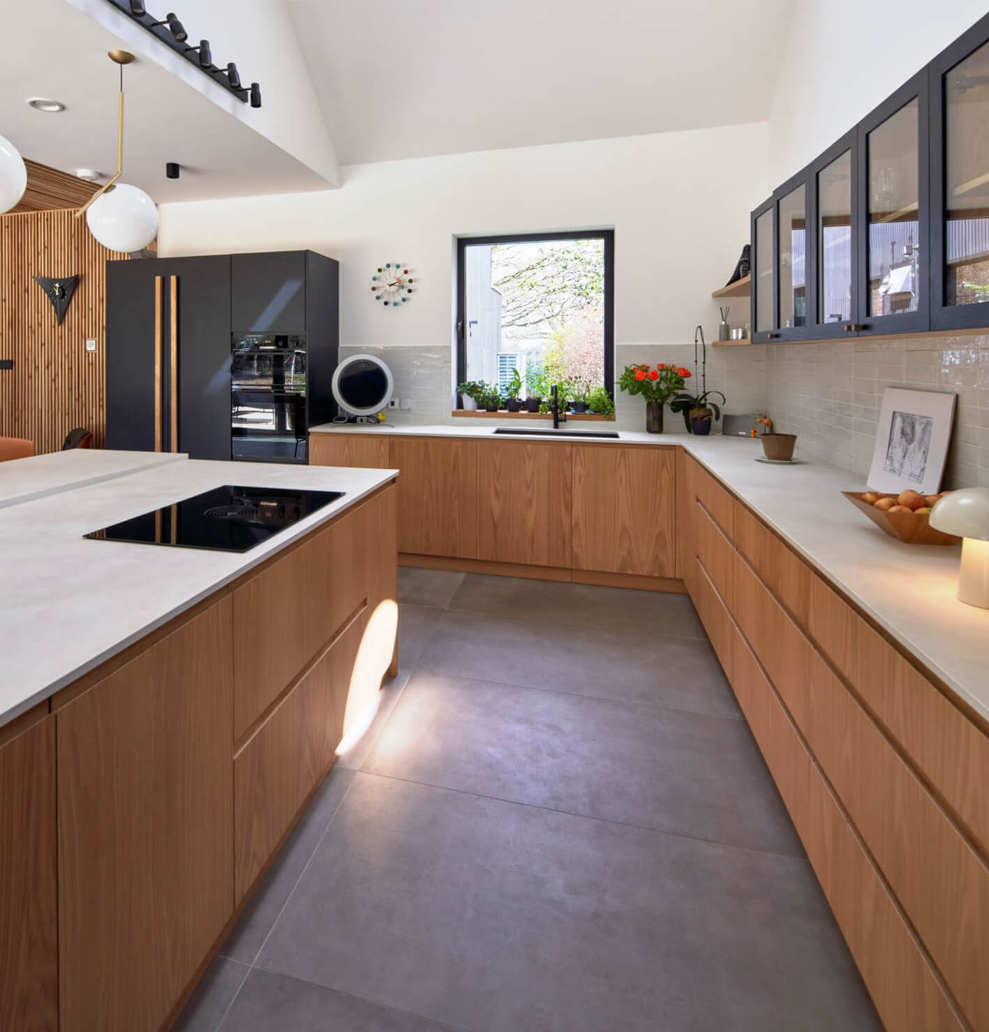 Large black and oak kitchen with glazed wall cabinet with j-groove doors and an island with a v-groove finish