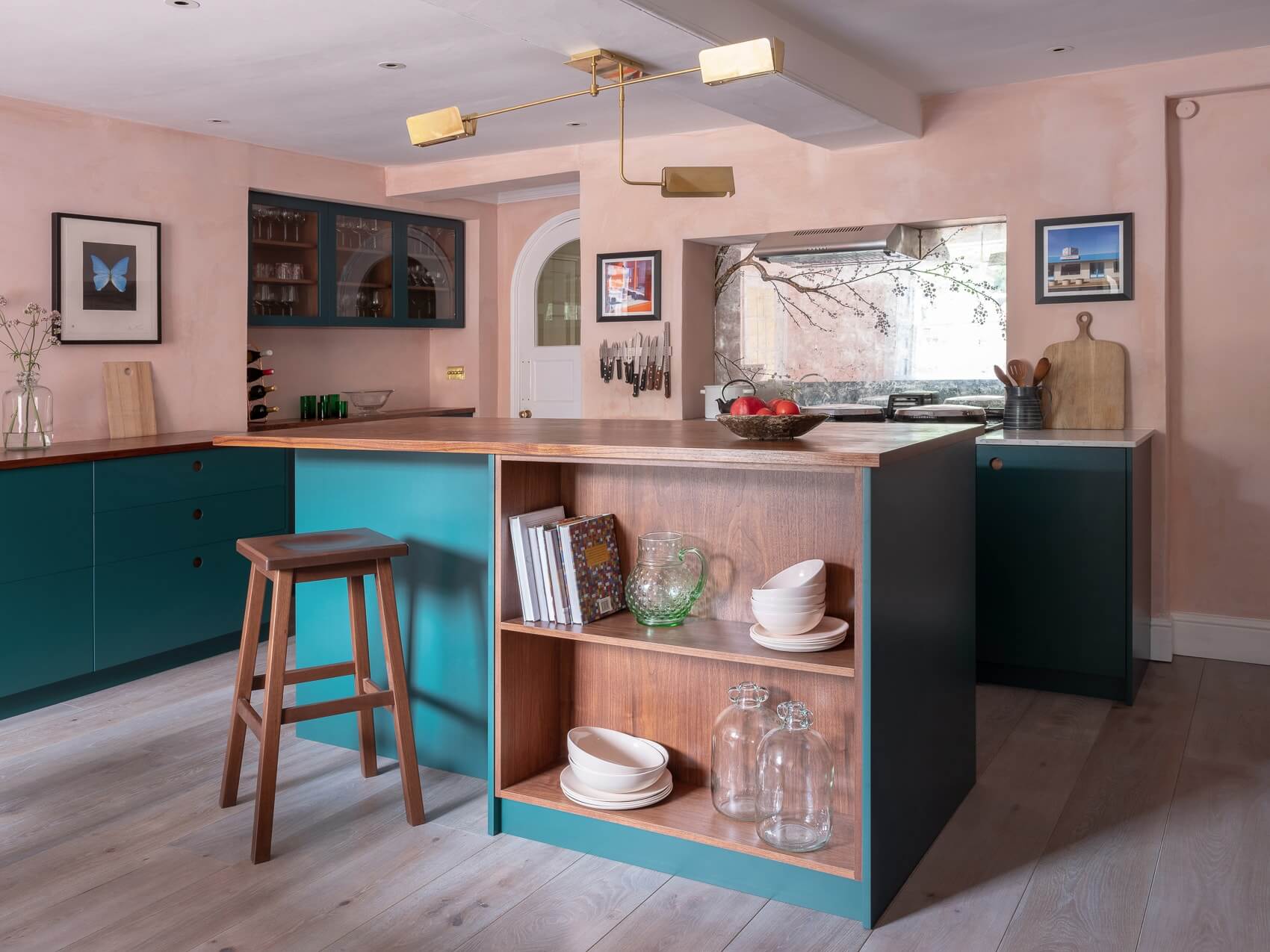 A chic and contemporary masterpiece, the circular handle detail and bold red Aga are the showstoppers. Walnut and the rich green-blue work harmoniously while brass accents add a touch of elegance.