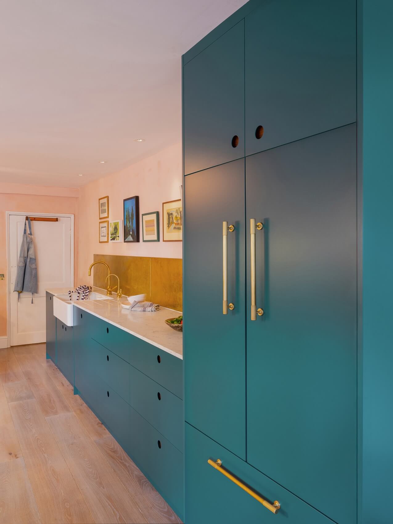 A chic and contemporary masterpiece, the circular handle detail and bold red Aga are the showstoppers. Walnut and the rich green-blue work harmoniously while brass accents add a touch of elegance.