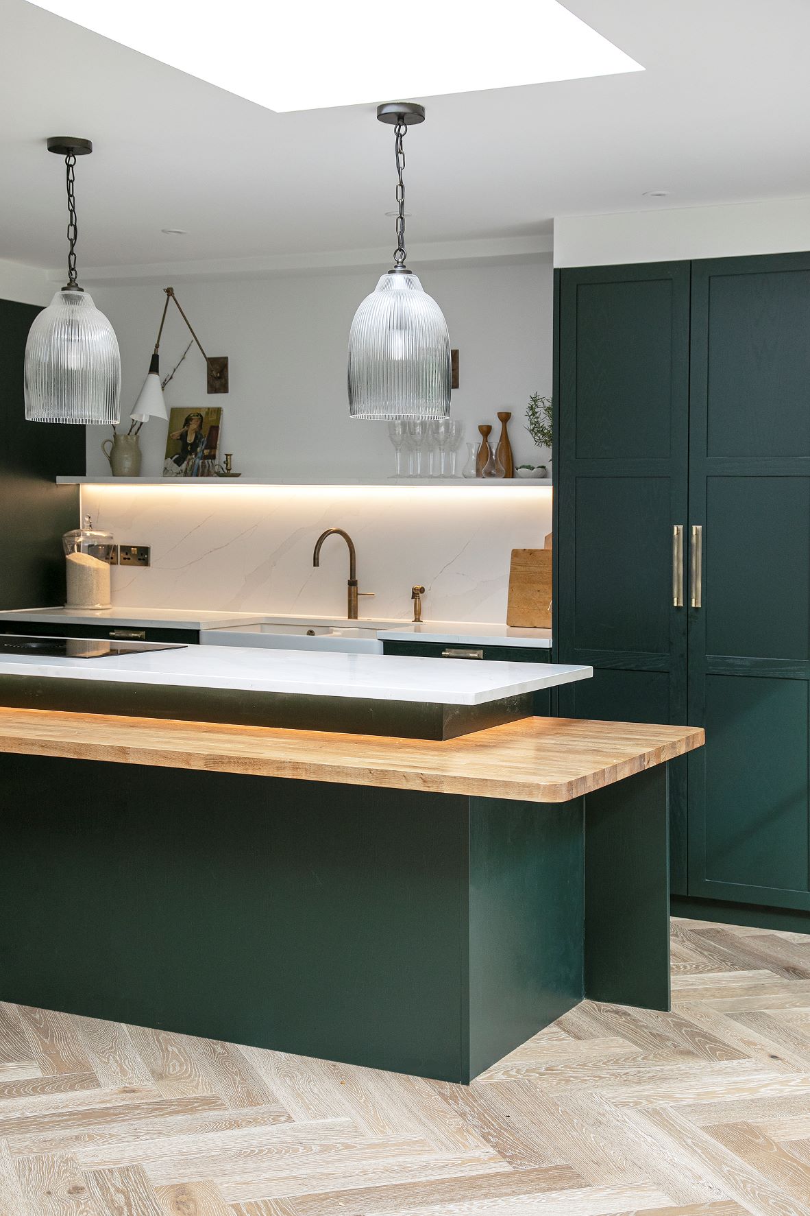 black shaker style kitchen with integrated oven and white worktops and a central island to match